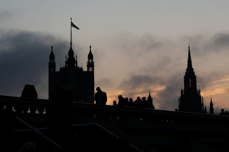 © Reuters. FILE PHOTO: Demonstrators stand on Westminster Bridge, next to the Houses of Parliament, in London