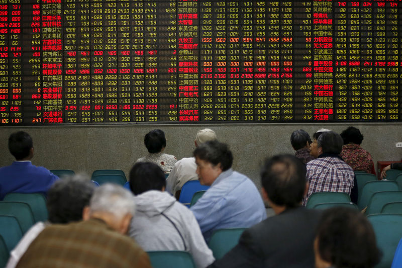 © Reuters. FILE PHOTO: Investors look at an electronic board showing stock information at a brokerage house in Shanghai,