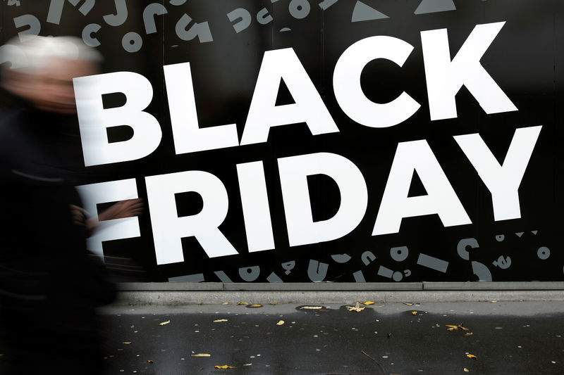 © Reuters. A man walks past a sign advertising 'Black Friday' sales on a retail shop window in Paris