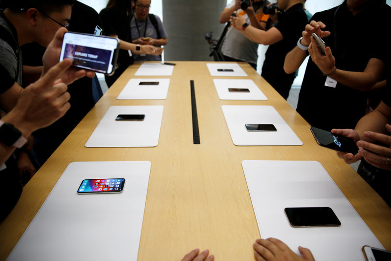 © Reuters. FILE PHOTO: People handle the new Apple iPhone XS and iPhone XS Max during a media tour at an Apple office in Shanghai
