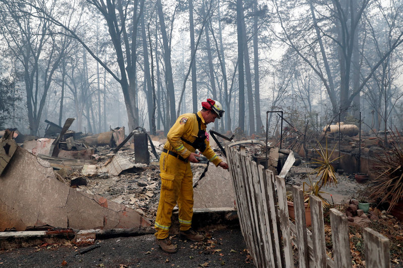 © Reuters. Bombeiro inspeciona casa destruída por incêndio florestal em Paradise, na Califórnia