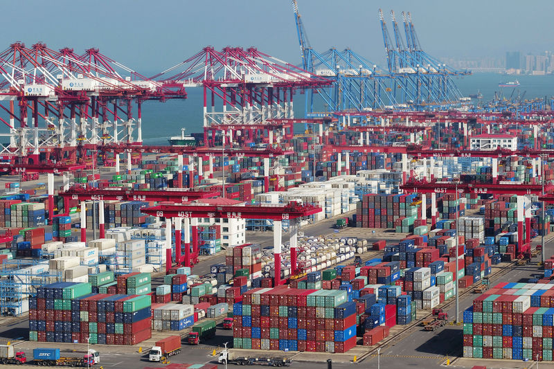 © Reuters. FILE PHOTO:  Containers and trucks are seen at a terminal of the Qingdao port in Shandong