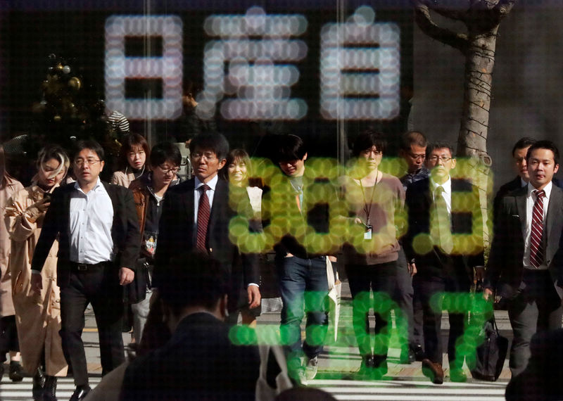 © Reuters. People are reflected in a stock quotation board showing share price of Nissan Motor Co outside a brokerage in Tokyo