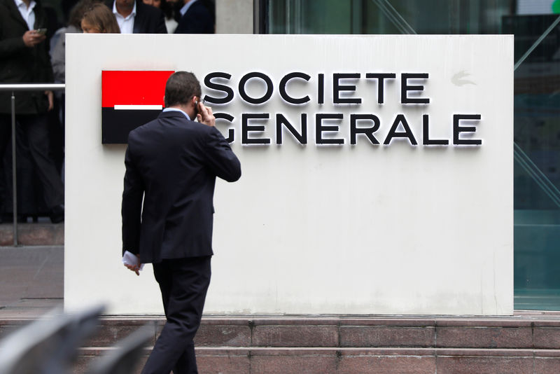 © Reuters. A man passes by the logo on the headquarters of French bank Societe Generale at the financial and business district of La Defense at Puteaux near Paris