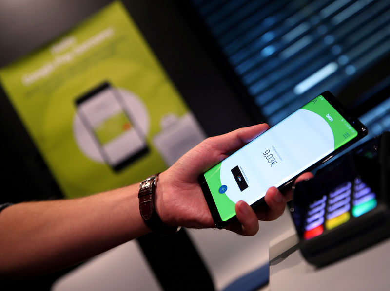 © Reuters. FILE PHOTO: An employee of Wirecard AG, presents the contactless payment system "boon" at the company's headquarters in Aschheim