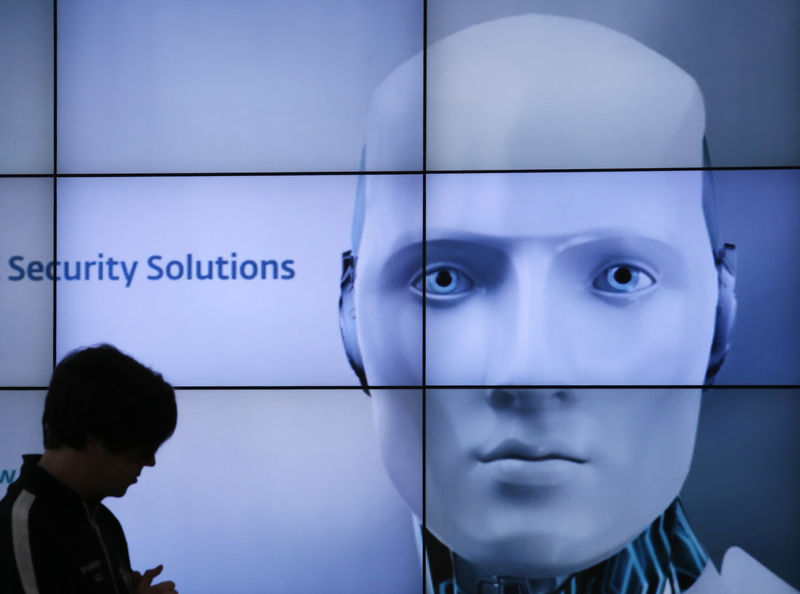 © Reuters. A woman is silhouetted at the ESET booth during preparations at the CeBit computer fair in Hanover
