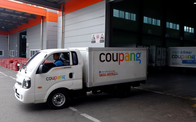 © Reuters. Delivery trucks for e-commerce retailer Coupang leave a distribution centre in Seoul