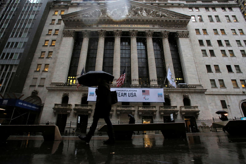 © Reuters. People walk by the New York Stock Exchange (NYSE) during the morning commute in the financial district during a winter nor'easter in New York