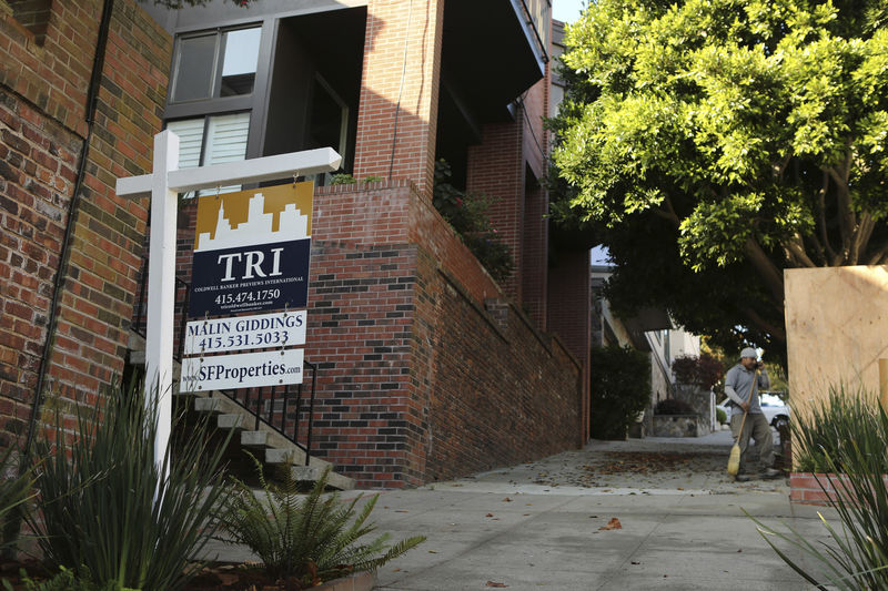 © Reuters. A man stands near a sign advertising a home for sale in the Pacific Heights neighborhood in San Francisco