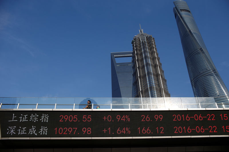 © Reuters. People walk past electronic board showing benchmark Shanghai and Shenzhen stock indices, on a pedestrian overpass at Pudong financial district in Shanghai,