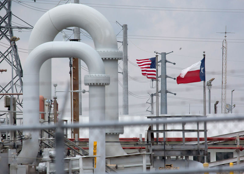 © Reuters. A maze of crude oil pipe and equipment is seen with the American and Texas flags flying during a tour by the Department of Energy at the Strategic Petroleum Reserve in Freeport