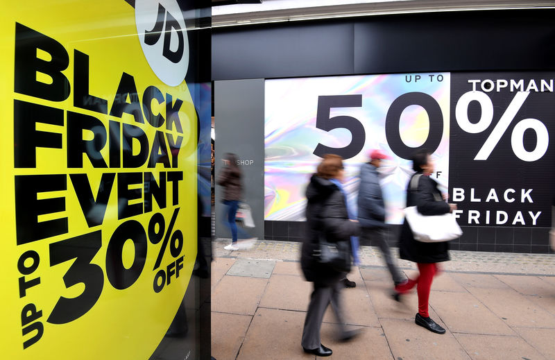 © Reuters. Shoppers walk past Black Friday signage on Oxford Street in London