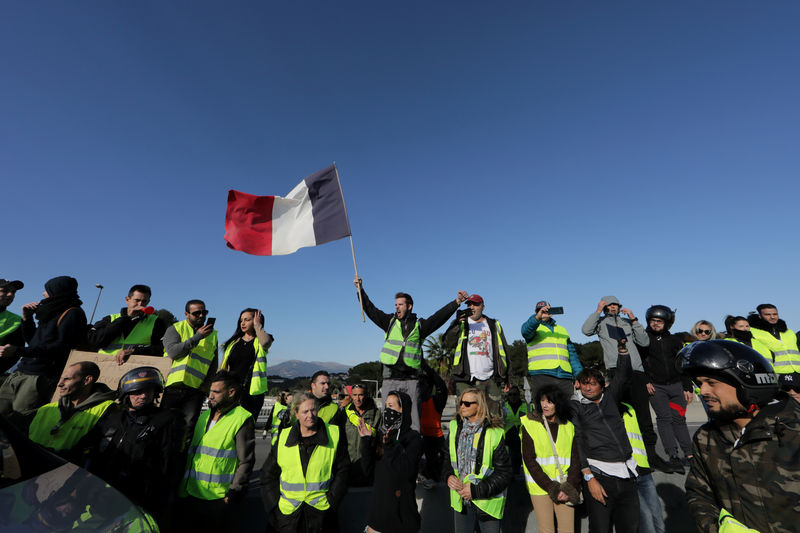 © Reuters. FILE PHOTO: People wearing yellow vests, a symbol of a French drivers' protest against higher fuel prices, block the motorway in Antibes