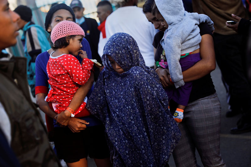 © Reuters. Migrantes, parte de una caravana de miles de centroamericanos que intentan llegar a Estados Unidos, hacen fila esperando alimentos en un refugio temporal en Tijuana