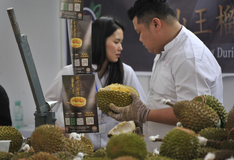 © Reuters. Promoters work at a booth of Musang King durians at the Malaysia Durian Festival in Nanning