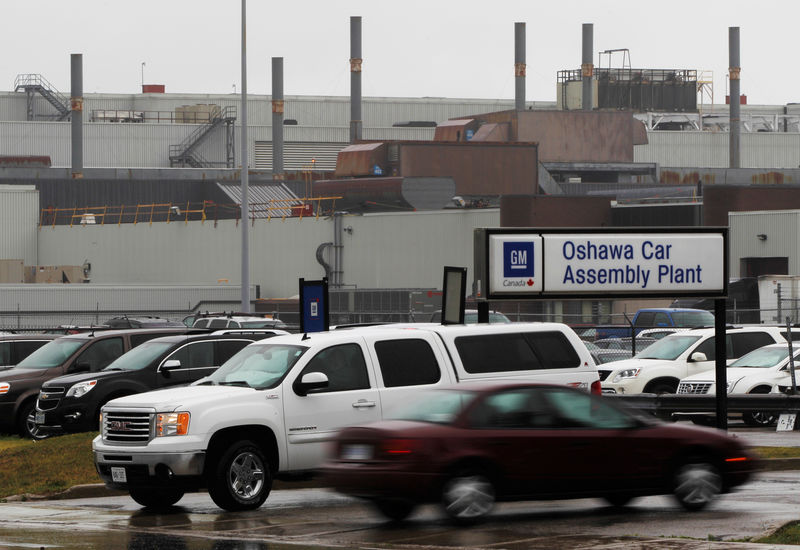 © Reuters. FILE PHOTO: People drive cars in front of the General Motors Car assembly plant in Oshawa
