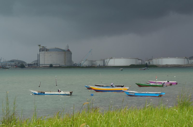 © Reuters. FILE PHOTO: Boats float in front of the VOPAK oil storage terminal in Johor