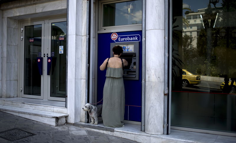 © Reuters. Woman uses a Eurobank ATM in Athens