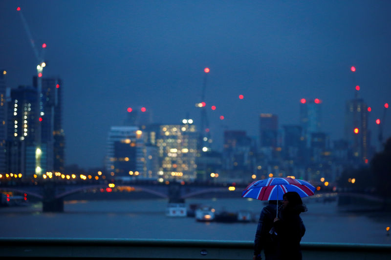 © Reuters. People walk under an umbrella on a wet afternoon on Westminster Bridge in London