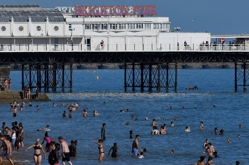 © Reuters. Beachgoers cool down in the sea during hot weather at Brighton in southern Britain