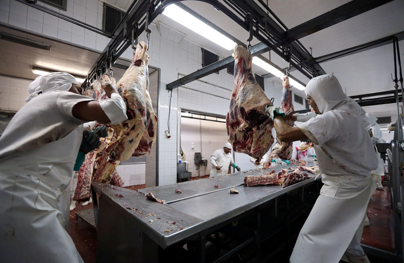 © Reuters. Workers handle beef carcasses at the Ecocarne Meat Plant slaughterhouse in San Fernando