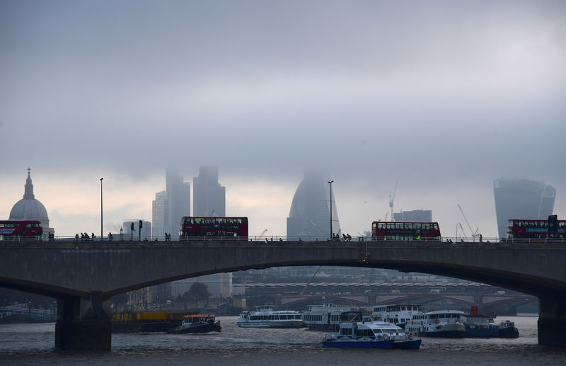 © Reuters. City workers cross the River Thames with the City of London financial district seen behind in London