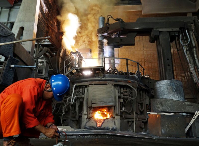 © Reuters. FILE PHOTO: A Man works in front of a furnace at a steel plant of Dalian Special Steel Co Ltd. in Dalian, Liaoning