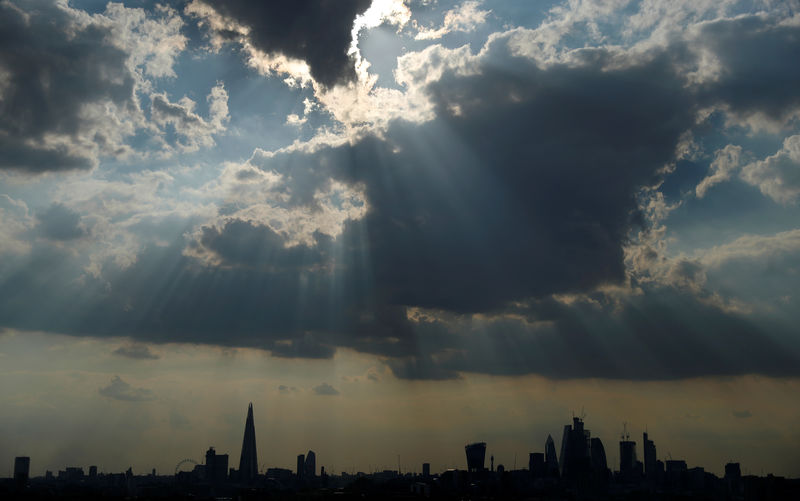 © Reuters. FILE PHOTO: Sunlight breaks through the clouds above the financial district of London