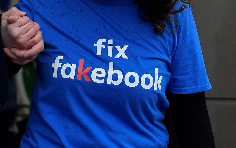 © Reuters. Un activista protesta por la ausencia del fundador y presidente de Facebook, Mark Zuckerberg, en una reunión sobre noticias falsas organizada por el comité digital, de medios culturales y deportes del Parlamento en Londres.
