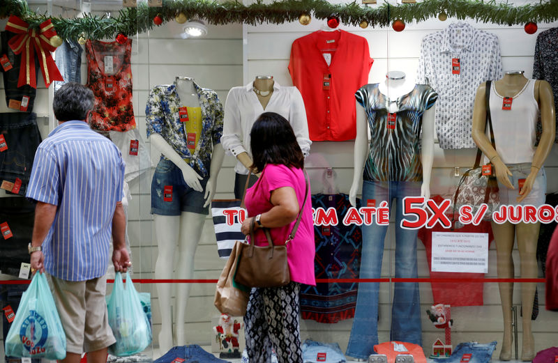 © Reuters. Consumidores passam por vitrine de loja em São Paulo