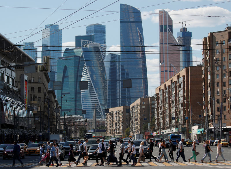© Reuters. FILE PHOTO:  Pedestrians cross the road as skyscrapers of the Moscow International Business Center, also known as "Moskva-City", are seen in the background in Moscow