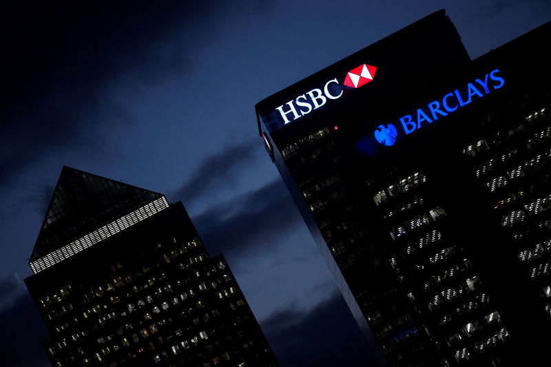 © Reuters. FILE PHOTO: HSBC and Barclay's buildings are lit up at dusk in the Canary Wharf financial district of London
