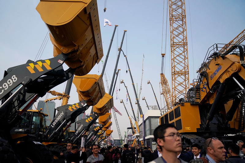 © Reuters. People visit heavy machinery at Bauma China, the International Trade Fair for Construction Machinery in Shanghai