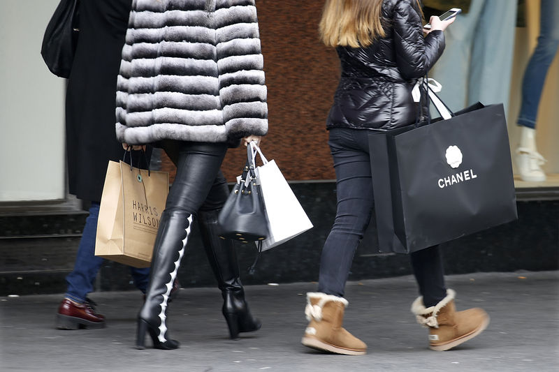 © Reuters. Customers carry shopping bags with purchases outside a department store in Paris