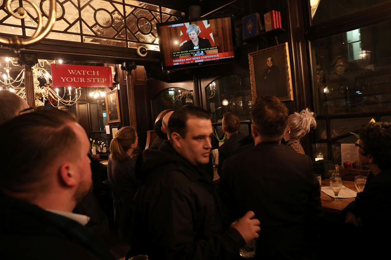 © Reuters. Clientes de pub de Londres acompanham entrevista coletiva de premiê britânica, Theresa May, pela televisão