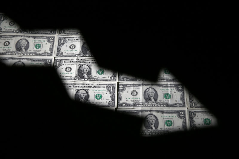 © Reuters. Dollar banknotes are seen through printed stock graph in this illustration