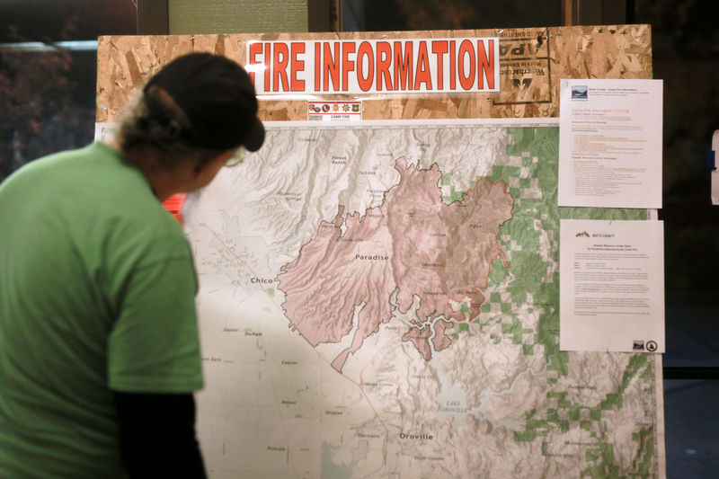 © Reuters. FILE PHOTO: A man looks at a map of the Camp Fire at a Red Cross shelter in Chico, California