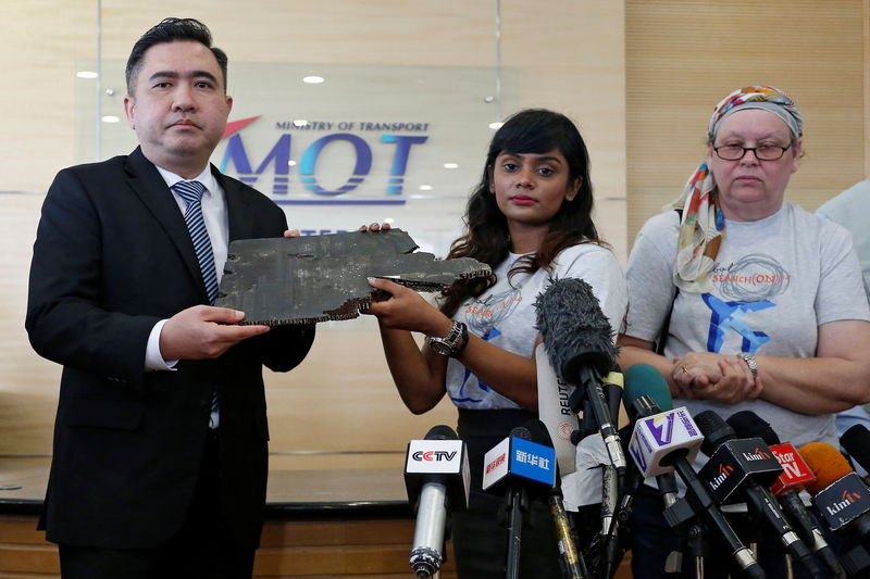 © Reuters. Grace Nathan, whose mother was onboard the missing Malaysia Airlines flight MH370, hands over a debris believed to belong to MH370 to Malaysia's Transport Minister Anthony Loke Siew Fook in Putrajaya