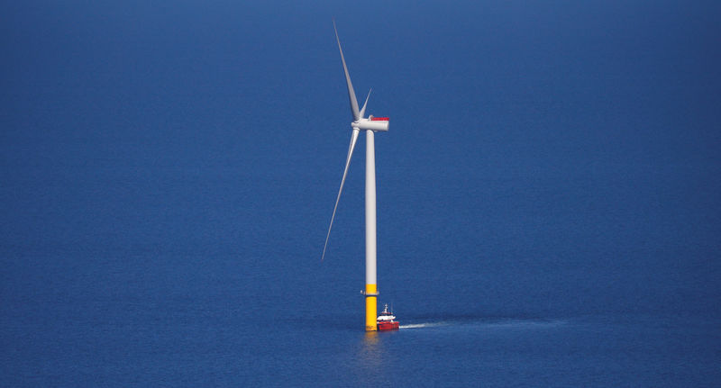 © Reuters. FILE PHOTO: A support vessel is seen next to a wind turbine at the Walney Extension offshore wind farm operated by Orsted off the coast of Blackpool