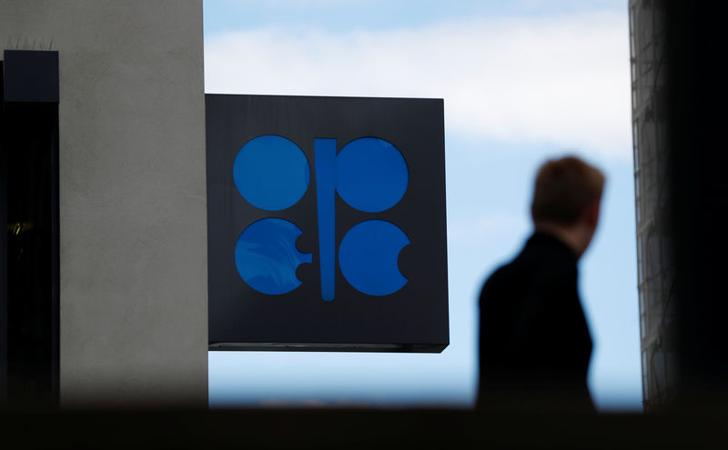 © Reuters. FILE PHOTO: A person passes the OPEC logo in front of OPEC's headquarters in Vienna