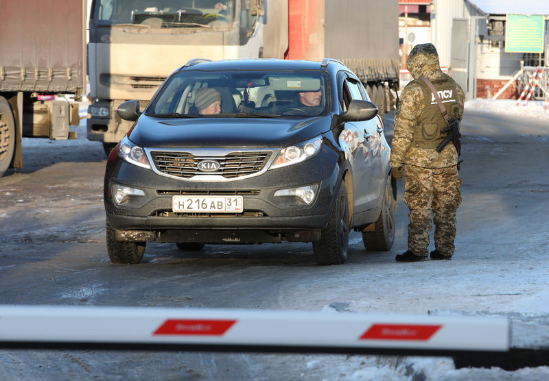 © Reuters. A member of the Ukrainian State Border Guard Service checks a car with a Russian number plate at the Goptovka crossing point on the border between Russia and Ukraine in Kharkiv Region