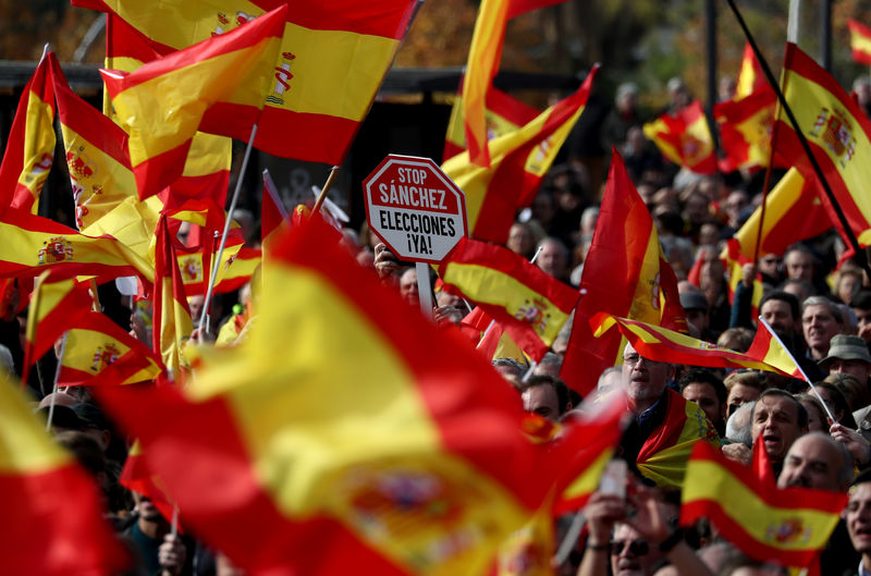 © Reuters. A man holds a placard reading "Stop Sanchez, Elections now" during a gathering calling for Spanish unity at Colon Square in Madrid