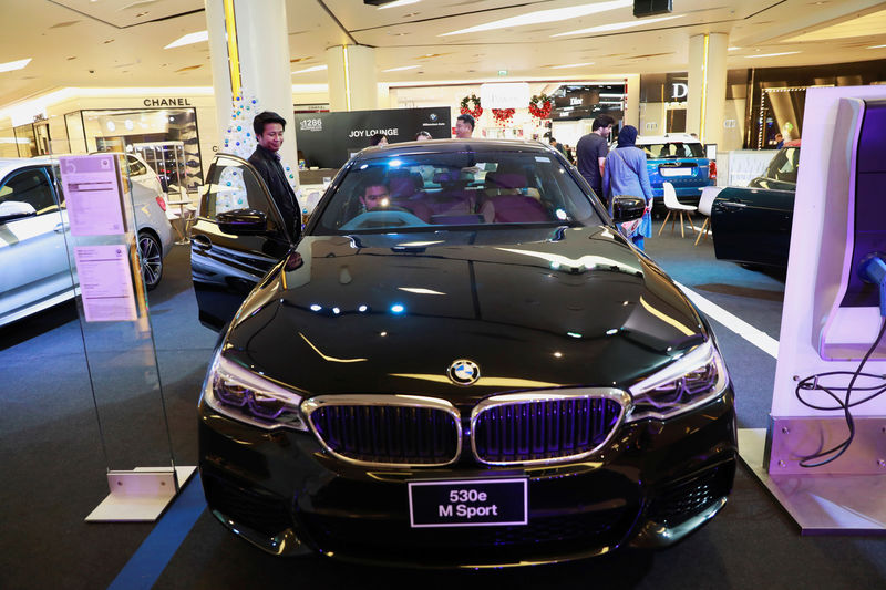 © Reuters. People try a new BMW 530e M Sport car at a car showroom at a shopping center in Bangkok