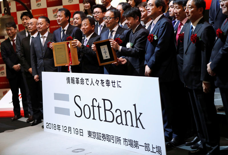 © Reuters. SoftBank Corp. President and CEO Ken Miyauchi poses as he holds an IPO certificate with Tokyo Stock Exchange director and executive officer Yasuyuki Konuma during a ceremony to mark the company's debut on the Tokyo Stock Exchange in Tokyo