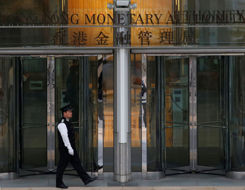 © Reuters. FILE PHOTO:  An attendant walks outside the entrance to Hong Kong Monetary Authority in Hong Kong