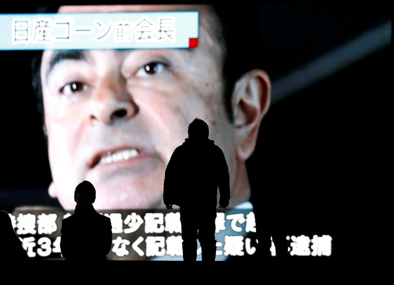 © Reuters. Passersby are silhouetted as a huge street monitor broadcasts news reporting ousted Nissan Motor chairman Carlos Ghosn's indictment and re-arrest in Tokyo