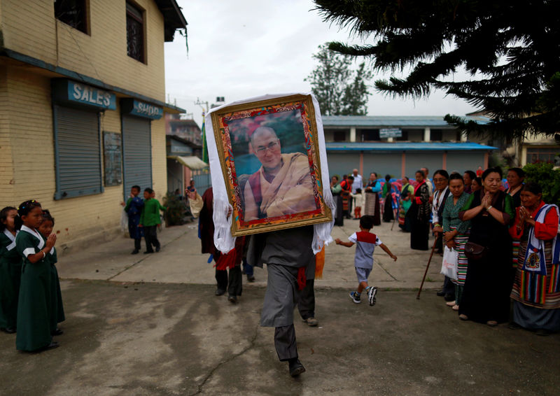 © Reuters. Homem carrega foto do Dalai Lama em Lalitpur, no Nepal