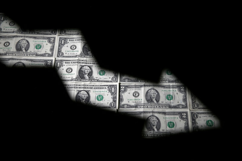 © Reuters. FILE PHOTO: Dollar banknotes are seen through printed stock graph in this illustration