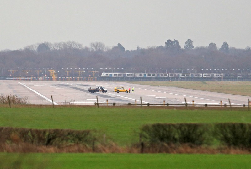© Reuters. Airport vehicles stand on the closed runway at Gatwick Airport after drones flying illegally over the airfield forced the closure of the airport, in Gatwick