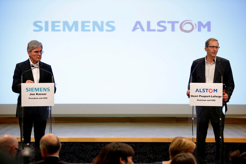 © Reuters. FILE PHOTO: Henri Poupart-Lafarge (right), Chairman and Chief Executive Officer of Alstom, and Siemens President and CEO Joe Kaeser announcing their deal to merge their rail operations